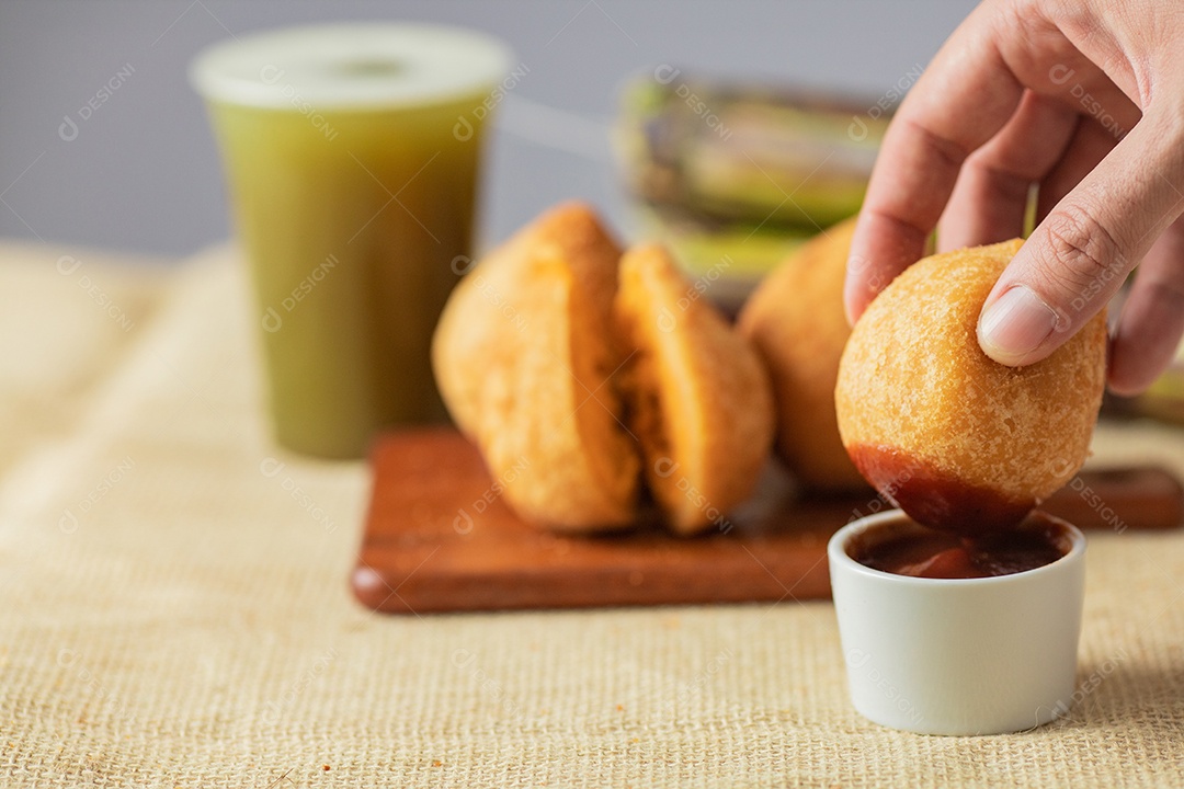 Salgados servidos com um copo de garapa