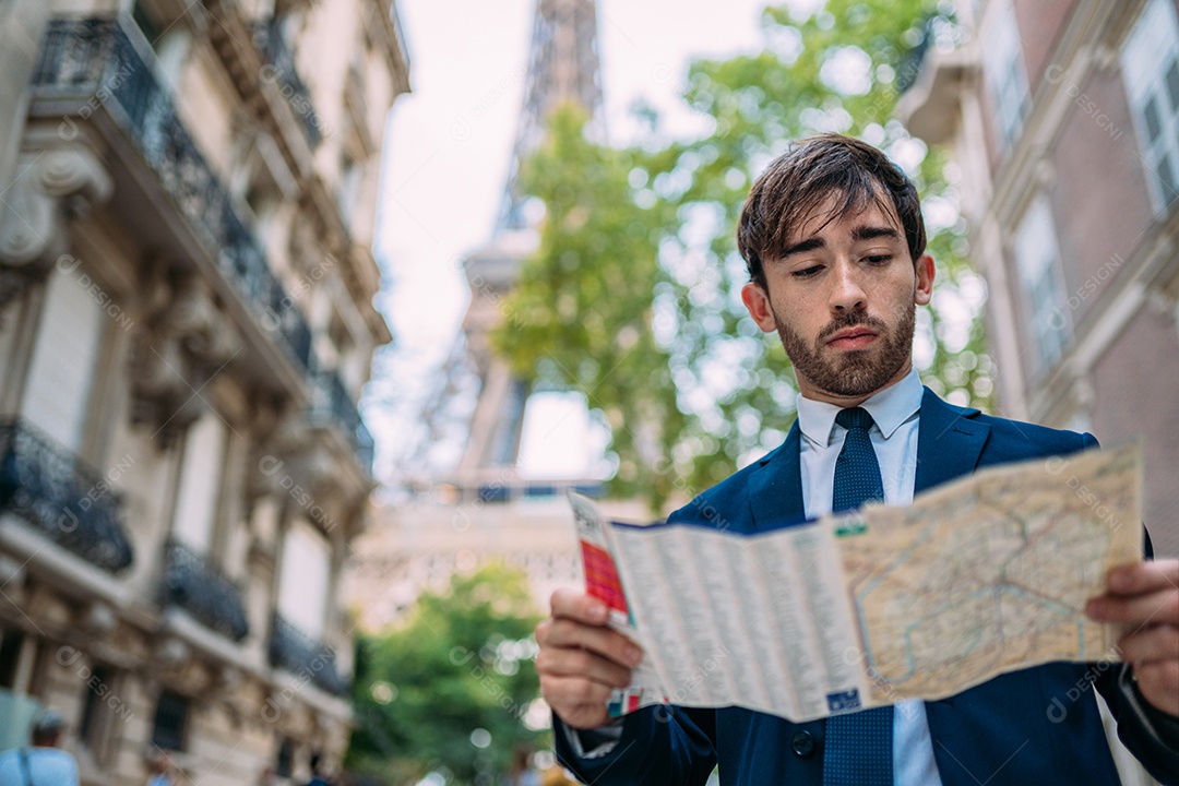 Férias em Paris. Homem de terno usando um mapa em Paris, França