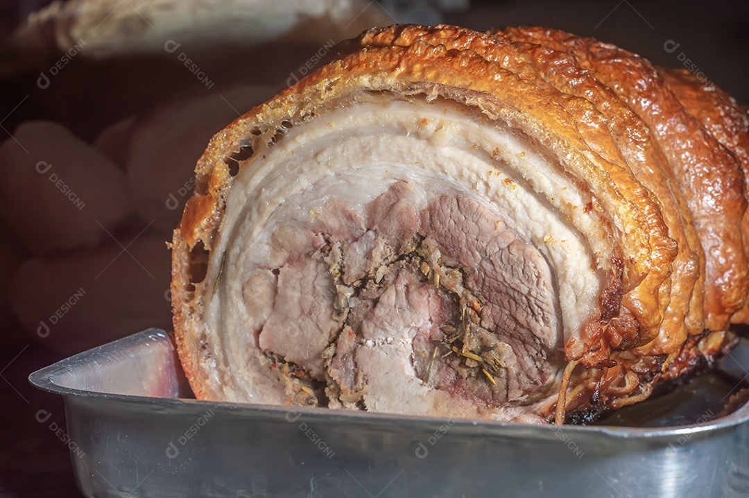 Assado caseiro de porchetta rolado, prancha de madeira, porchetta italiano em uma bandeja.
