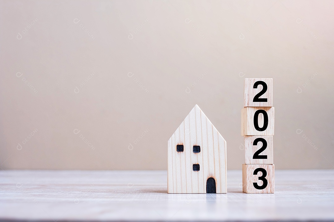 2023 feliz ano novo com modelo de casa no fundo de madeira da mesa. Conceitos bancários, imobiliários, de investimento, financeiros, de poupança e de resolução de ano novo