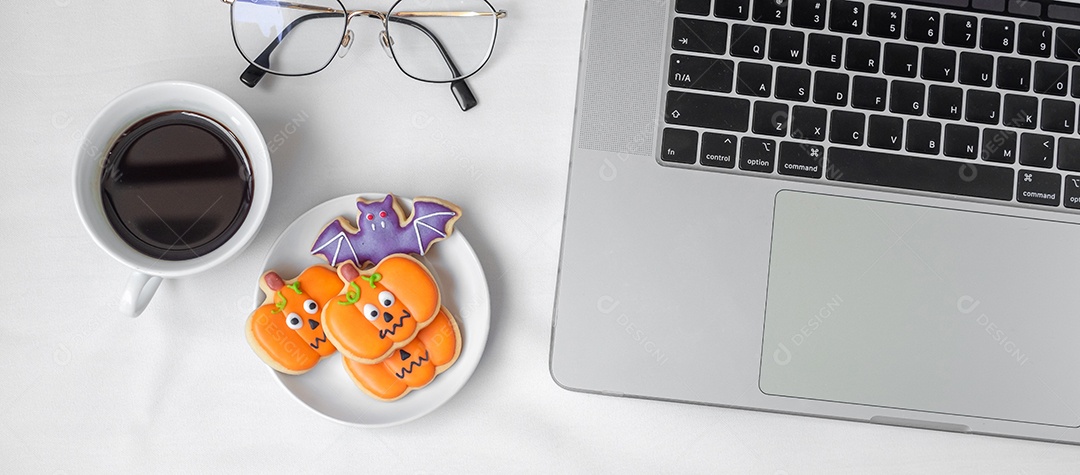 Biscoitos de Halloween, café quente e laptop de computador na parte traseira branca