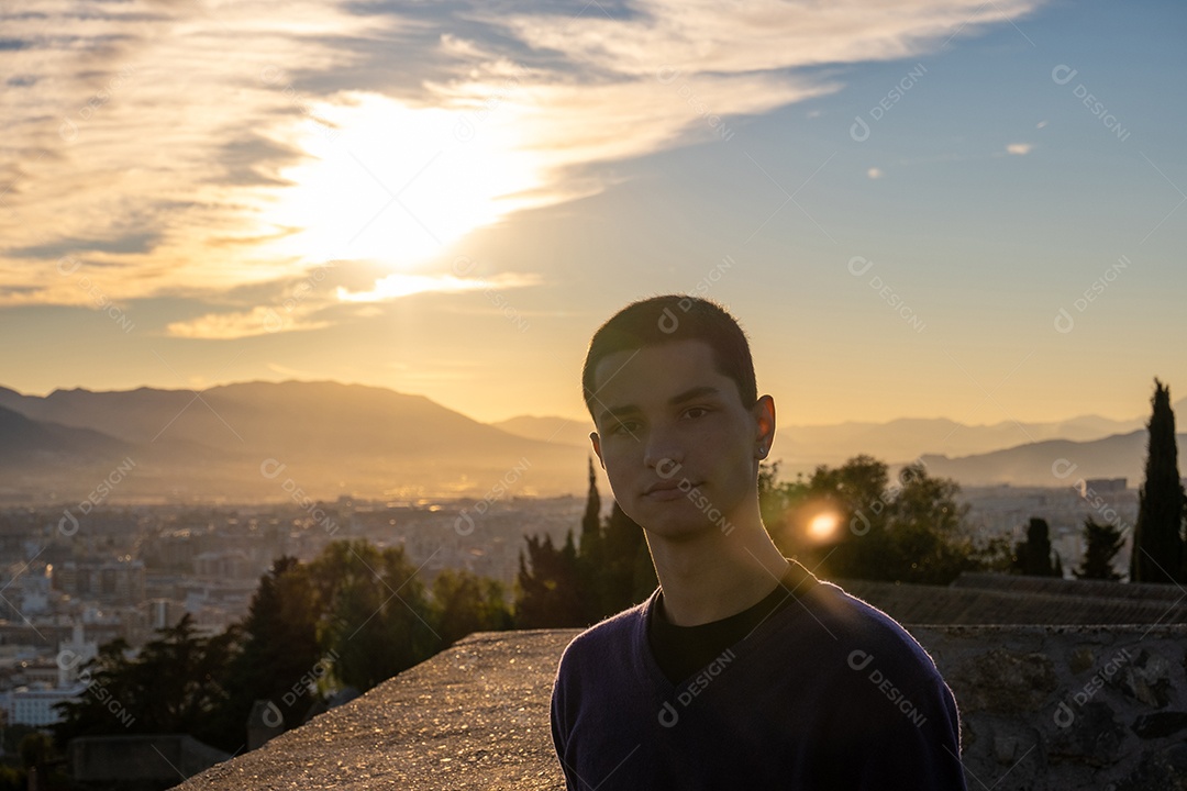 Jovem bonito com atitude positiva posando para a câmera com o mar ao fundo