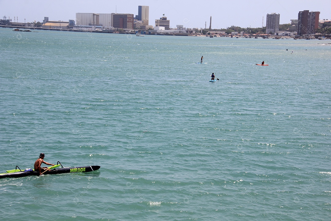 Homem sentado em caiaque no mar de aguas azuis