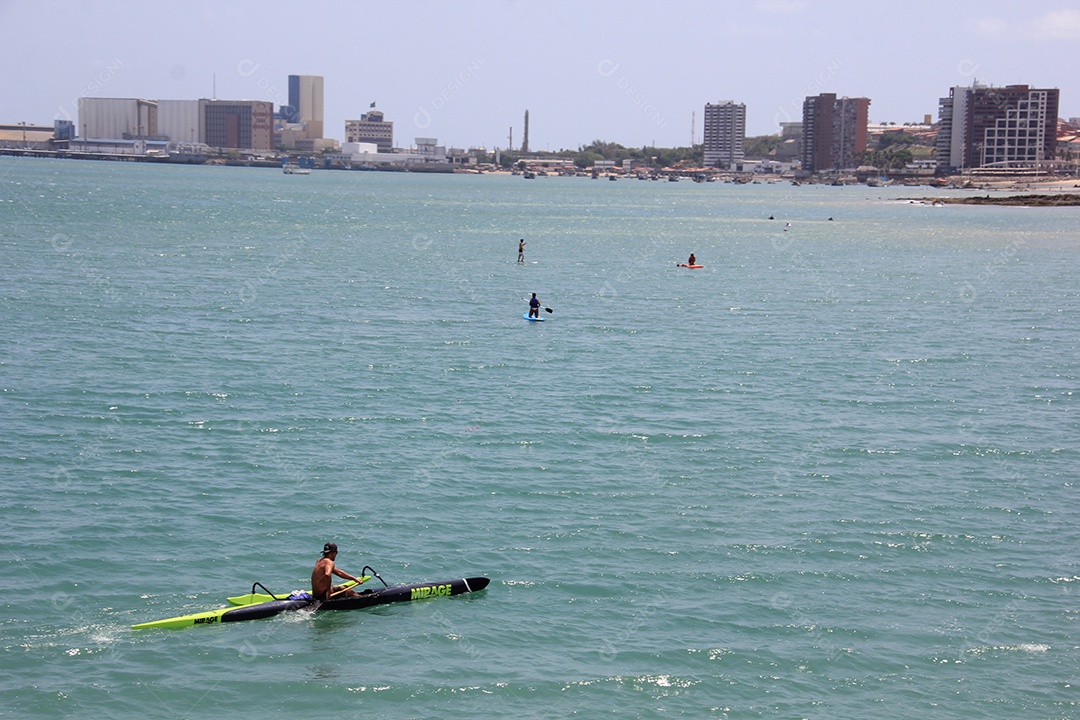 Homem sentado em caiaque no mar de aguas azuis