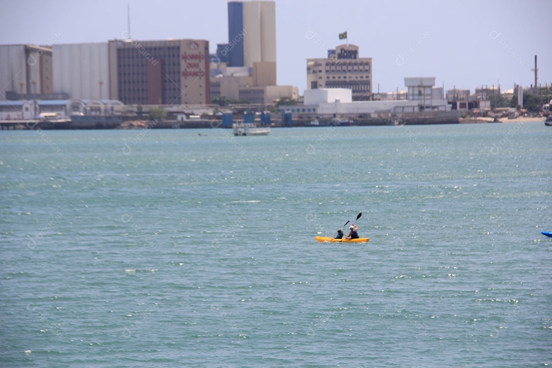 Homem sentado em caiaque no mar de aguas azuis