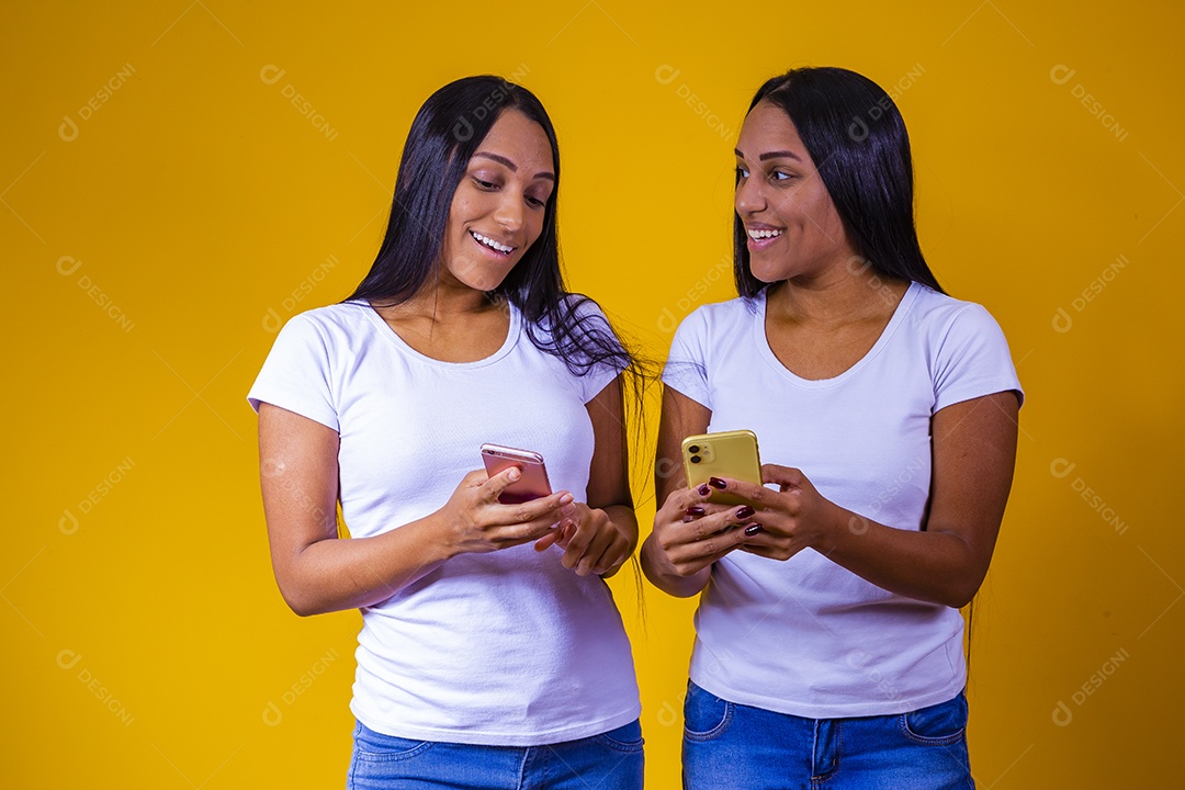 Lindas mulheres irmãs gêmeas segurando celular