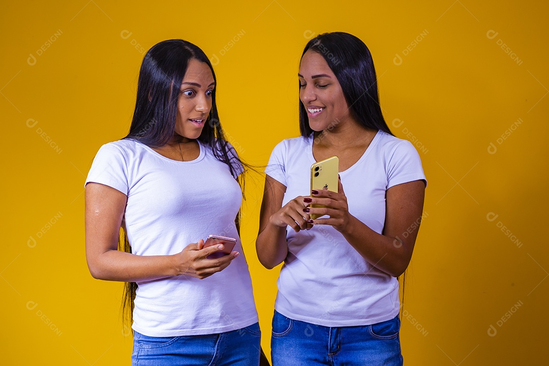 Lindas mulheres irmãs gêmeas segurando celular