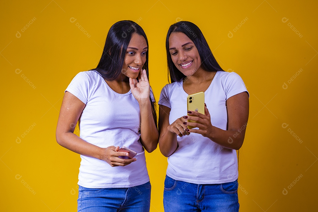Lindas mulheres irmãs gêmeas segurando celular