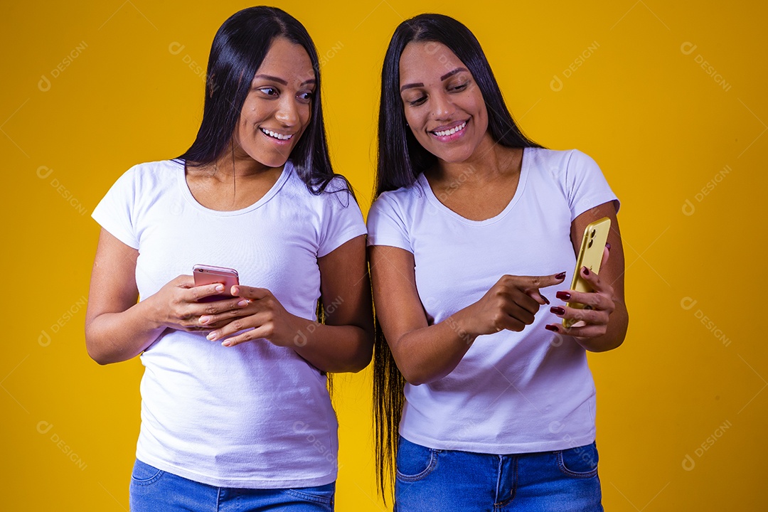 Lindas mulheres irmãs gêmeas segurando celular