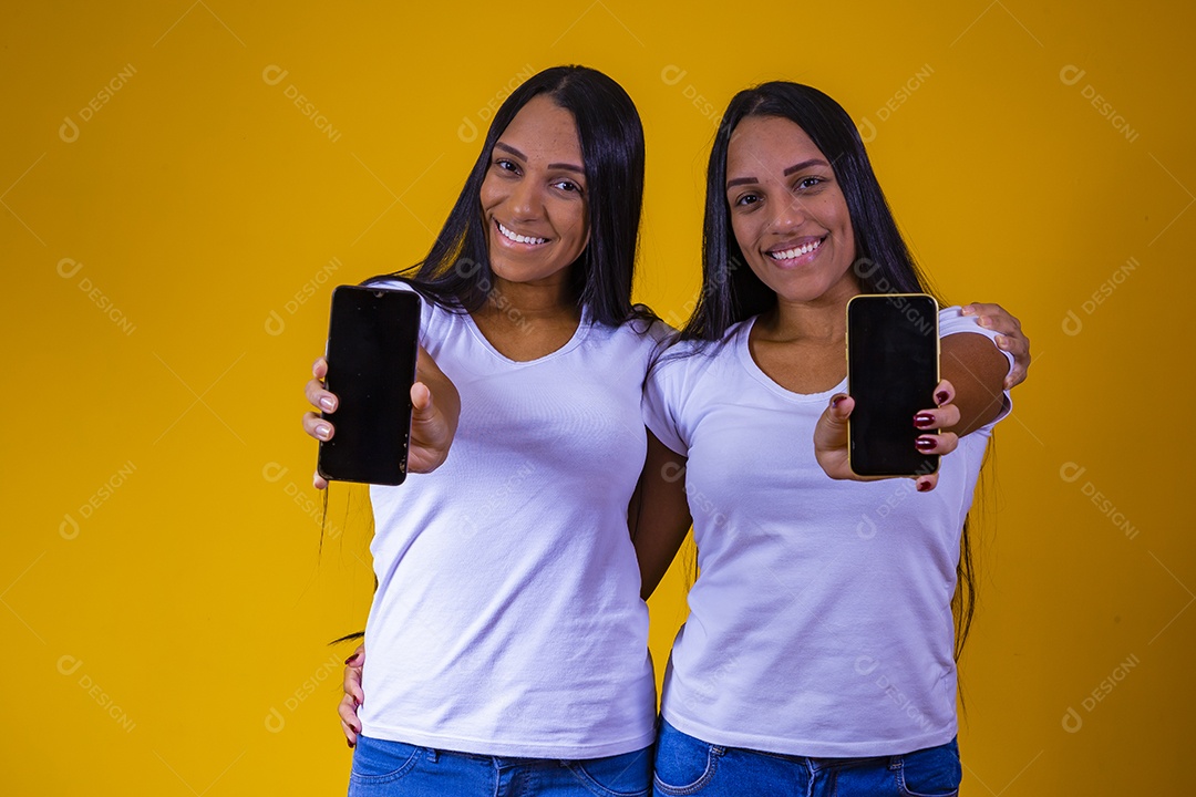 Lindas mulheres irmãs gêmeas segurando celular