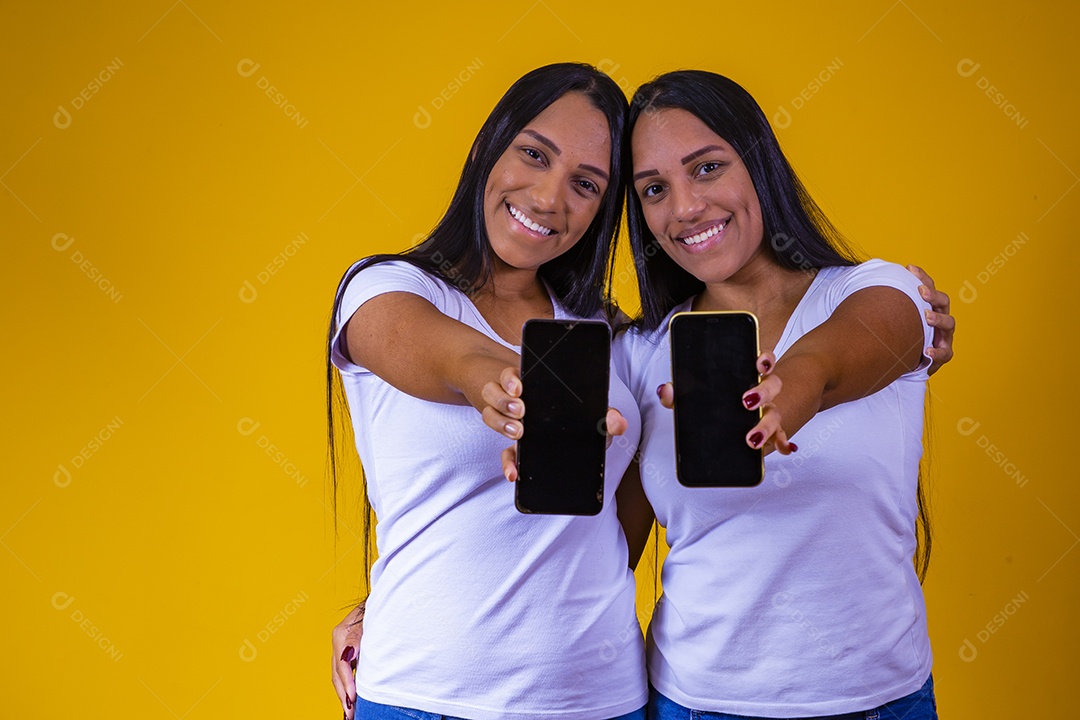 Lindas mulheres irmãs gêmeas segurando celular