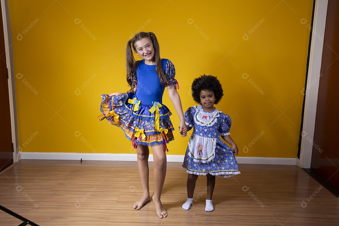 Lindas crianças irmãs fundo isolado amareloc