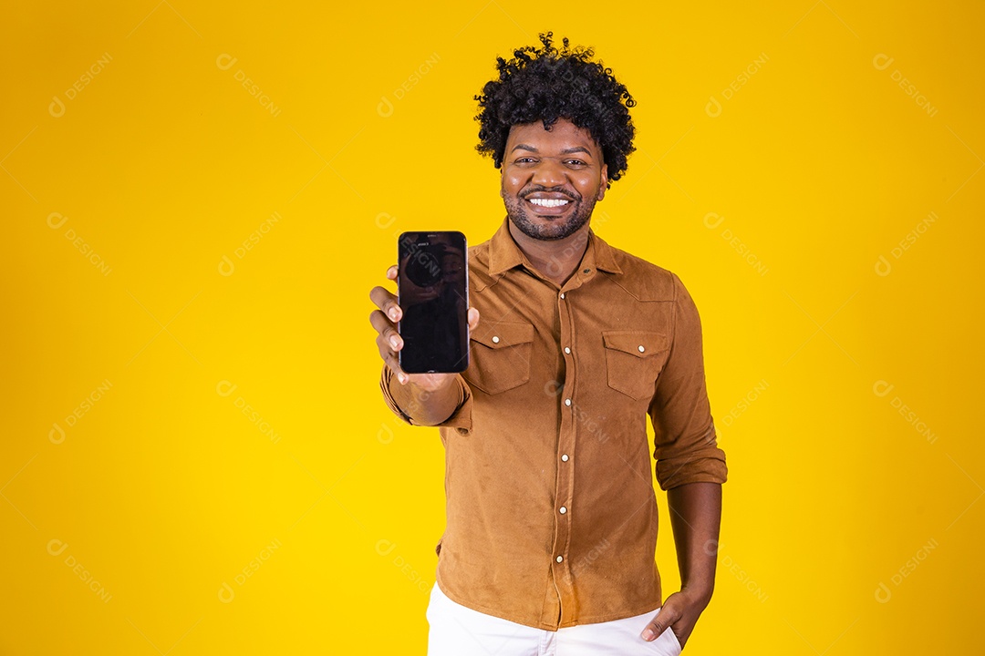 Homem jovem negro cabelo afro segurando seu celular fundo isolado