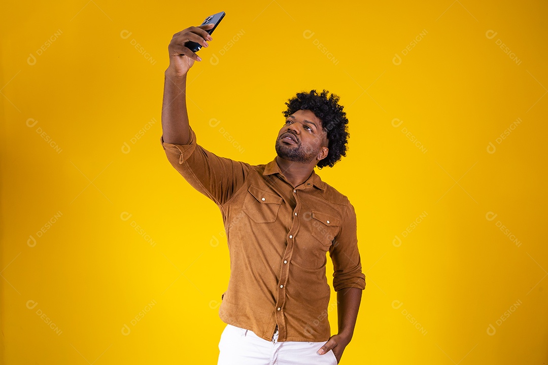 Homem jovem negro cabelo afro segurando seu celular fundo isolado
