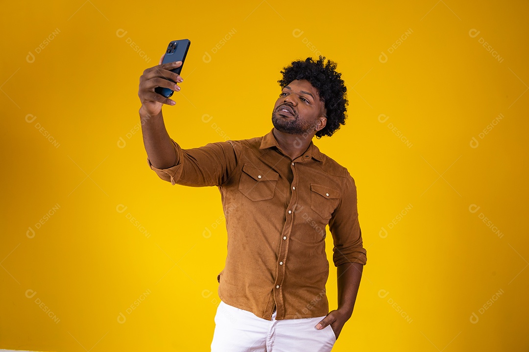 Homem jovem negro cabelo afro segurando seu celular fundo isolado