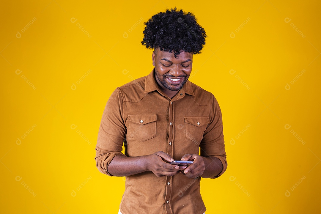 Homem jovem negro cabelo afro mexendo em seu celular fundo isolado