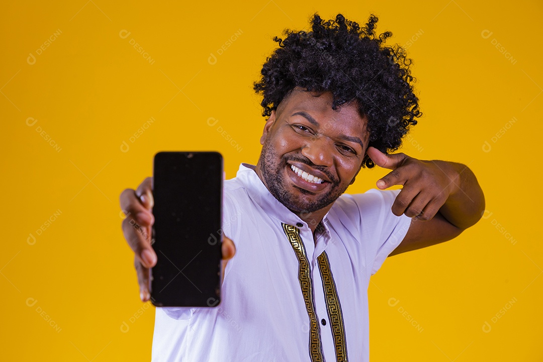 Homem jovem negro cabelo afro segurando seu celular fundo isolado