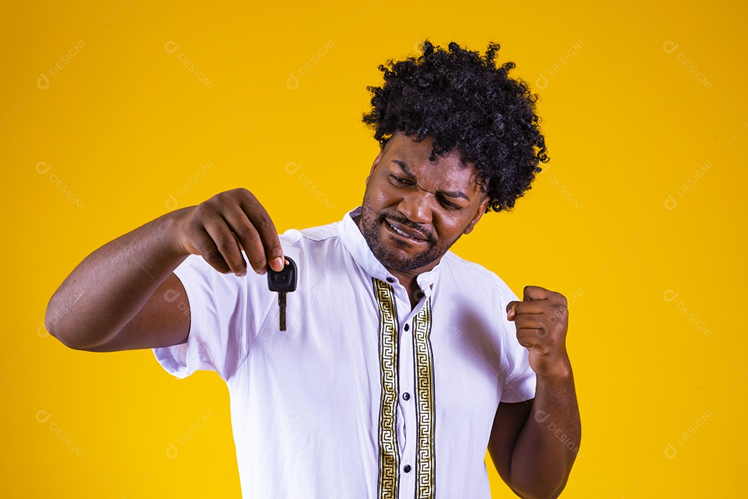 Homem jovem negro cabelo afro segurando chave de carro fundo isolado
