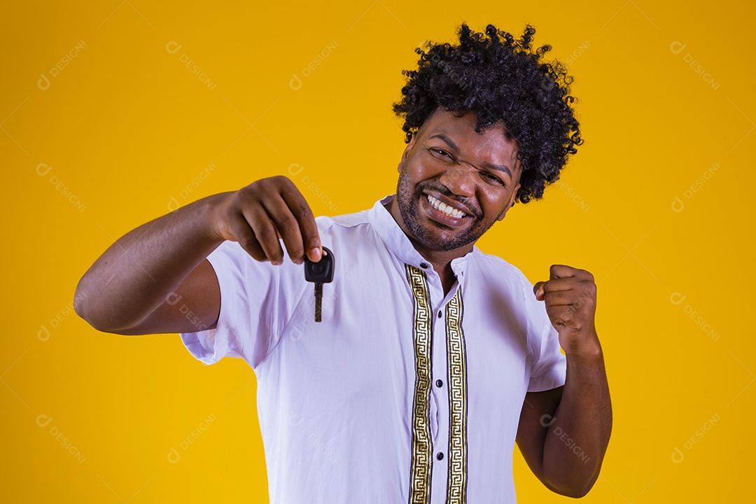 Homem jovem negro cabelo afro segurando chave de carro fundo isolado