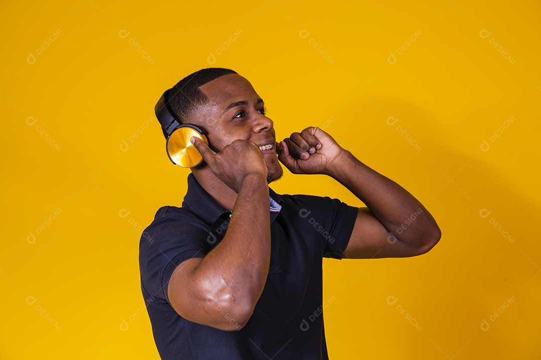 Homem jovem moreno sorridente e alegre ouvindo musica fone de ouvido