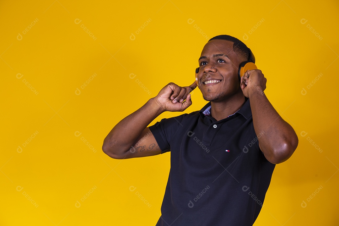 Homem jovem moreno sorridente e alegre ouvindo musica fone de ouvido