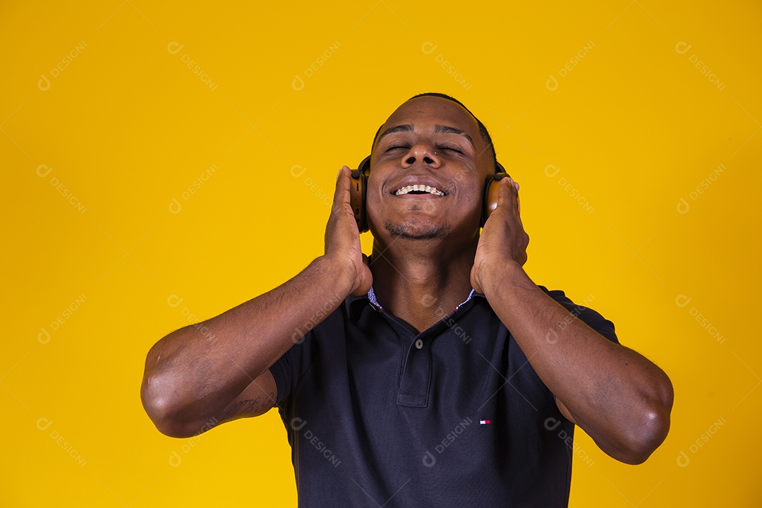 Homem jovem moreno sorridente e alegre ouvindo musica fone de ouvido