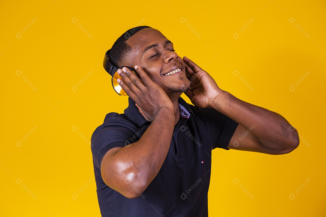 Homem jovem moreno sorridente e alegre ouvindo musica fone de ouvido