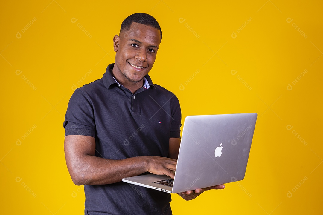 Homem jovem moreno sorridente e alegre usando notebook