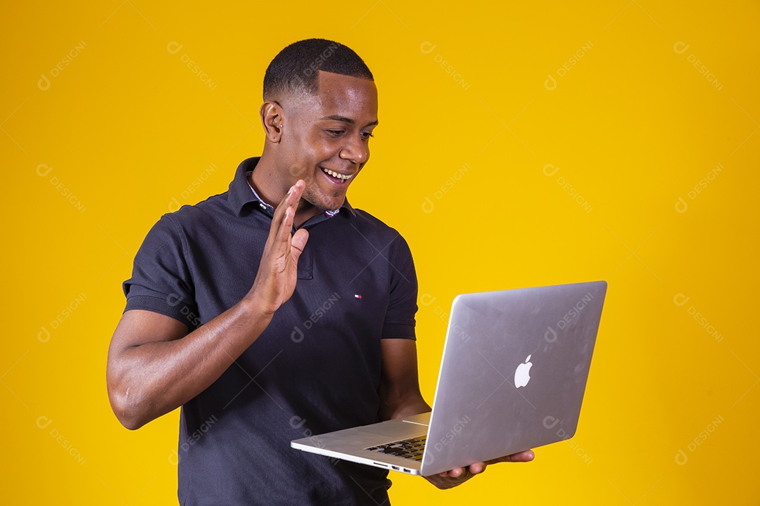 Homem jovem moreno sorridente e alegre usando notebook
