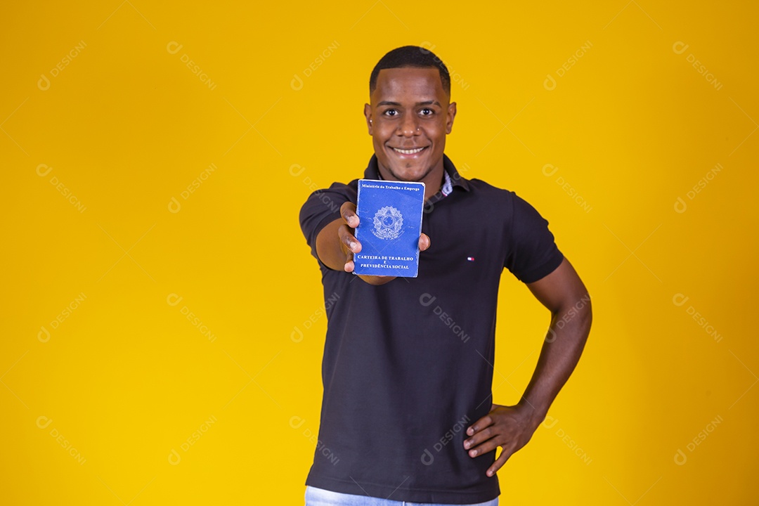 Homem jovem moreno sorridente e alegre segurando carteira de trabalho