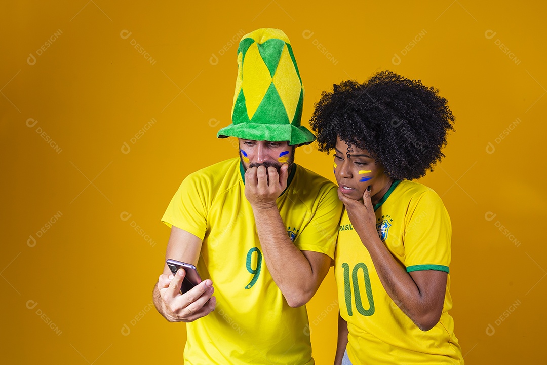 Casal jovens torcedores usando camisetas do brasil fundo isolado amarelo