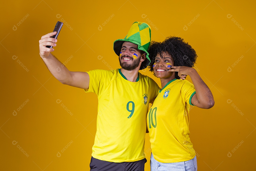 Casal jovens torcedores usando camisetas do brasil fundo isolado amarelo