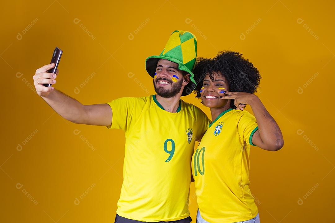 Casal jovens torcedores usando camisetas do brasil fundo isolado amarelo