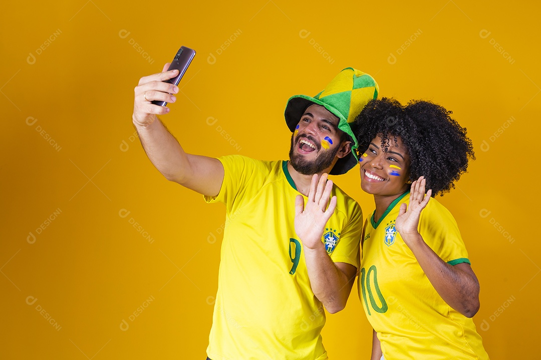 Casal jovens torcedores usando camisetas do brasil fundo isolado amarelo