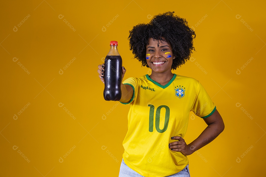 Linda mulher jovem torcedora usando camiseta brasil bebendo coca cola