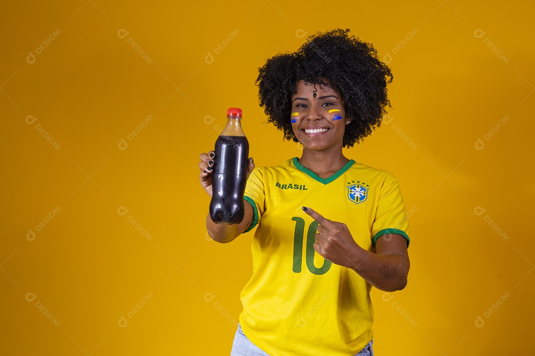 Linda mulher jovem torcedora usando camiseta brasil bebendo coca cola