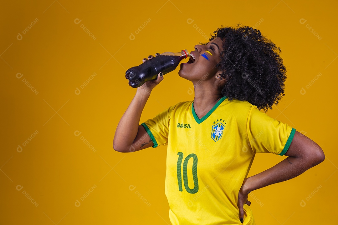 Linda mulher jovem torcedora usando camiseta brasil bebendo coca cola