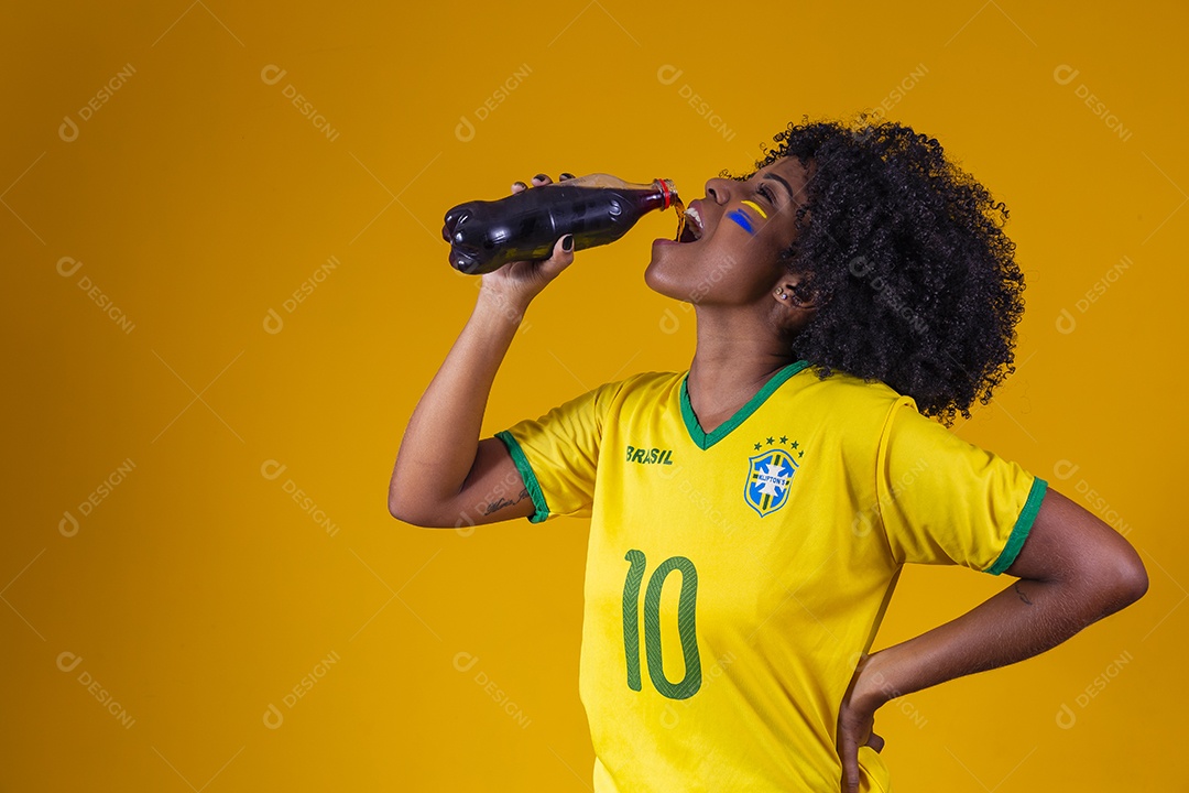 Linda mulher jovem torcedora usando camiseta brasil bebendo coca cola