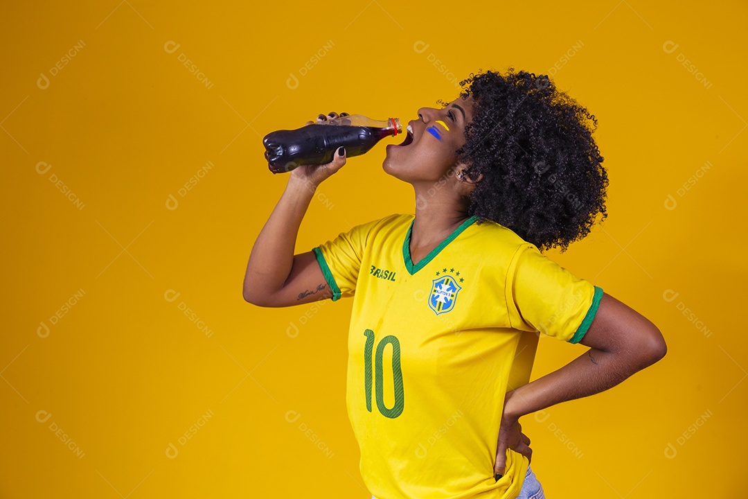 Linda mulher jovem torcedora usando camiseta brasil bebendo coca cola