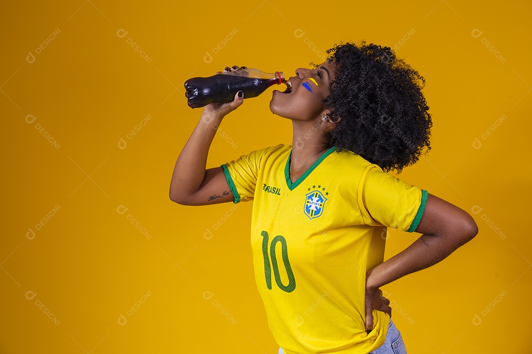 Linda mulher jovem torcedora usando camiseta brasil bebendo coca cola