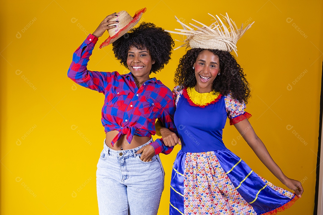 Lindas mulheres jovens garotas usando roupas fantasia São João sobre fundo amarelo