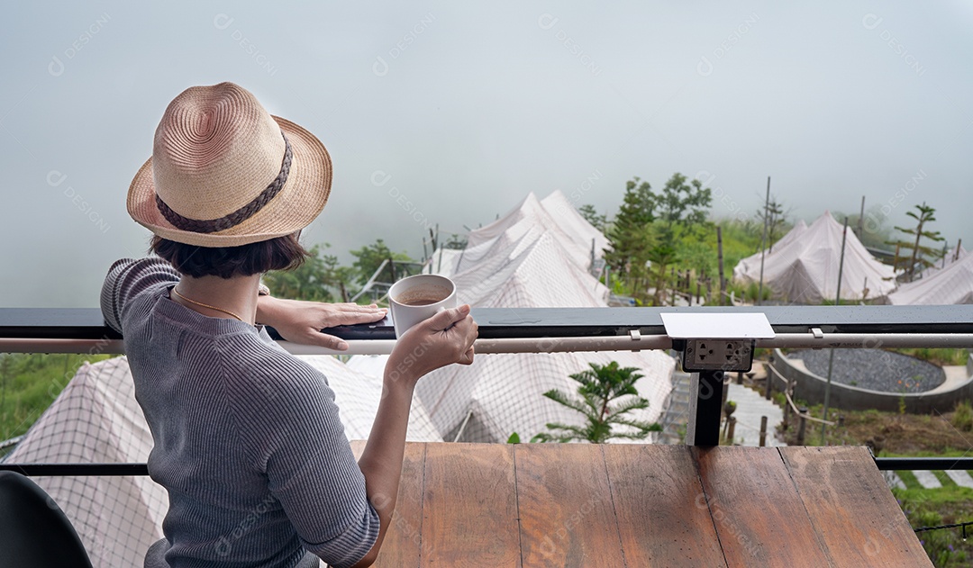 mulher segurando a xícara de cappuccino café turismo vista para a montanha.