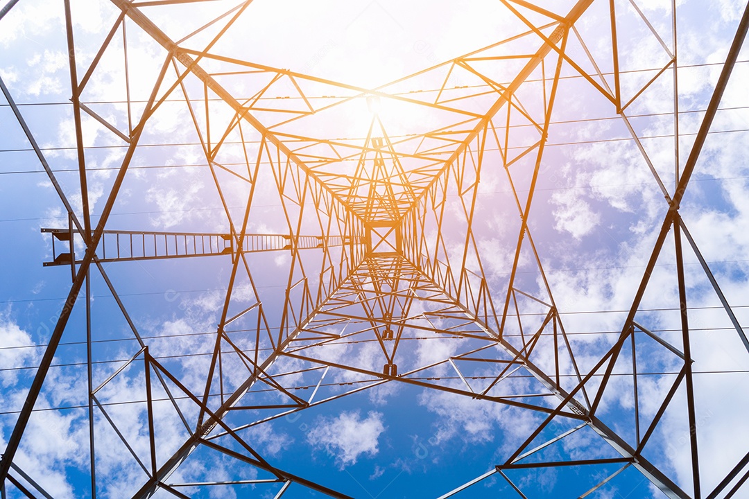 Torre elétrica de pólos de alta tensão no fundo do céu azul.