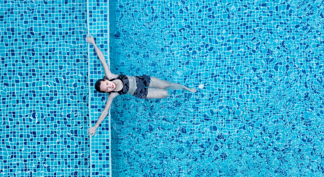 Vista aérea da garota ativa na piscina, relaxamento da mulher.