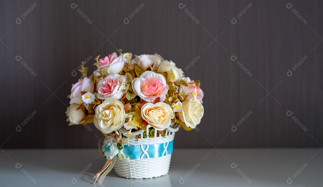 Rosas em um buquê de flores de cesta no chão de madeira.