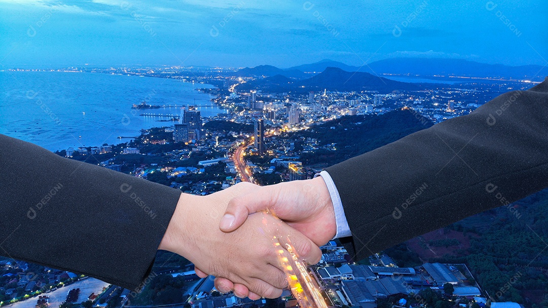 Homem de negócios executivo apertando a mão para o conceito de sucesso de acordo e parceria na cidade ao pôr do sol.
