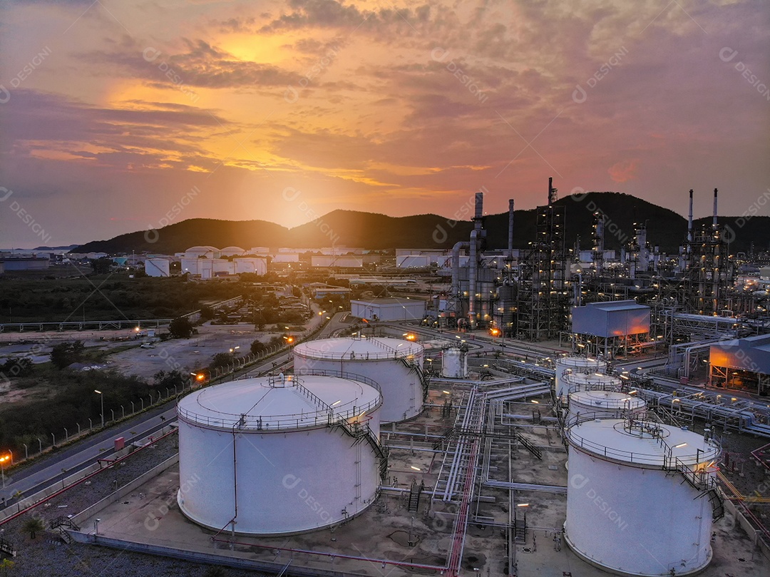 Tanque de óleo e refinaria de petróleo ao pôr do sol.