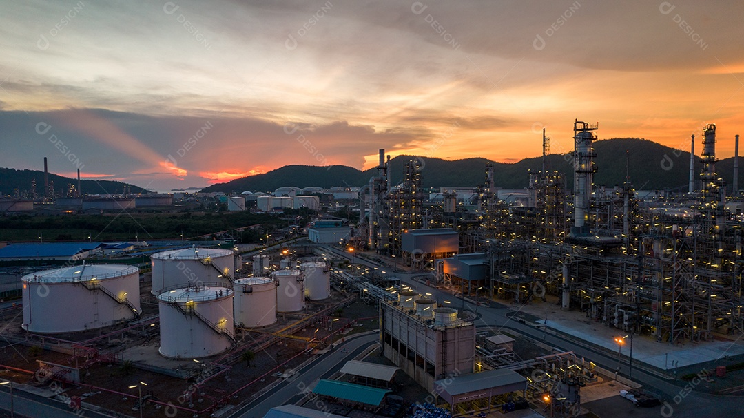 Planta de refinaria de petróleo química, usina e tubo de metal no fundo do céu por do sol.