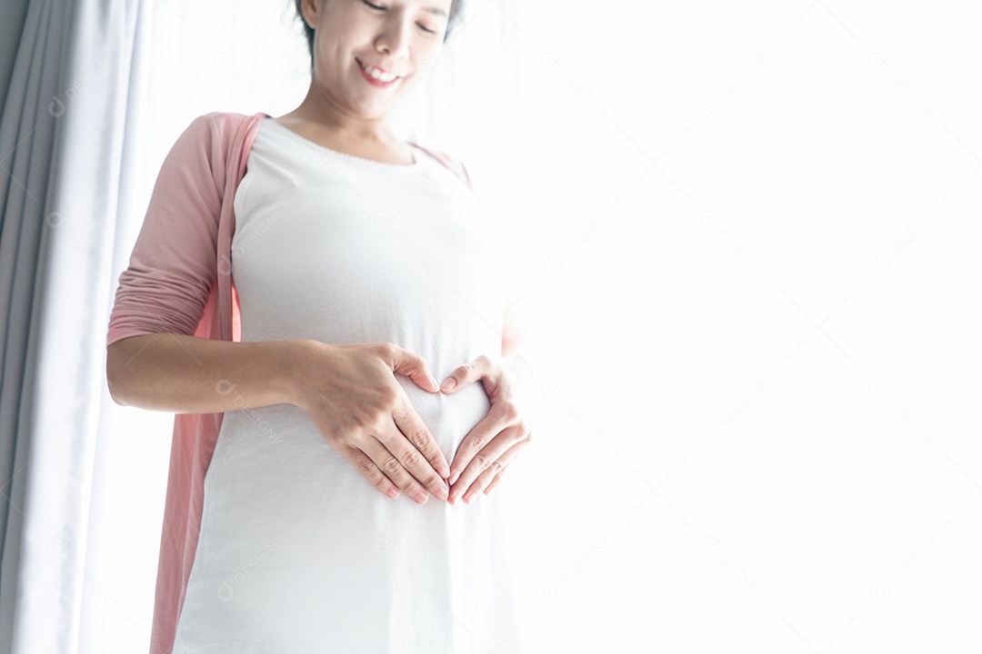 A mãe sorri e espera o bebê para uma mulher saudável e grávida tocando.