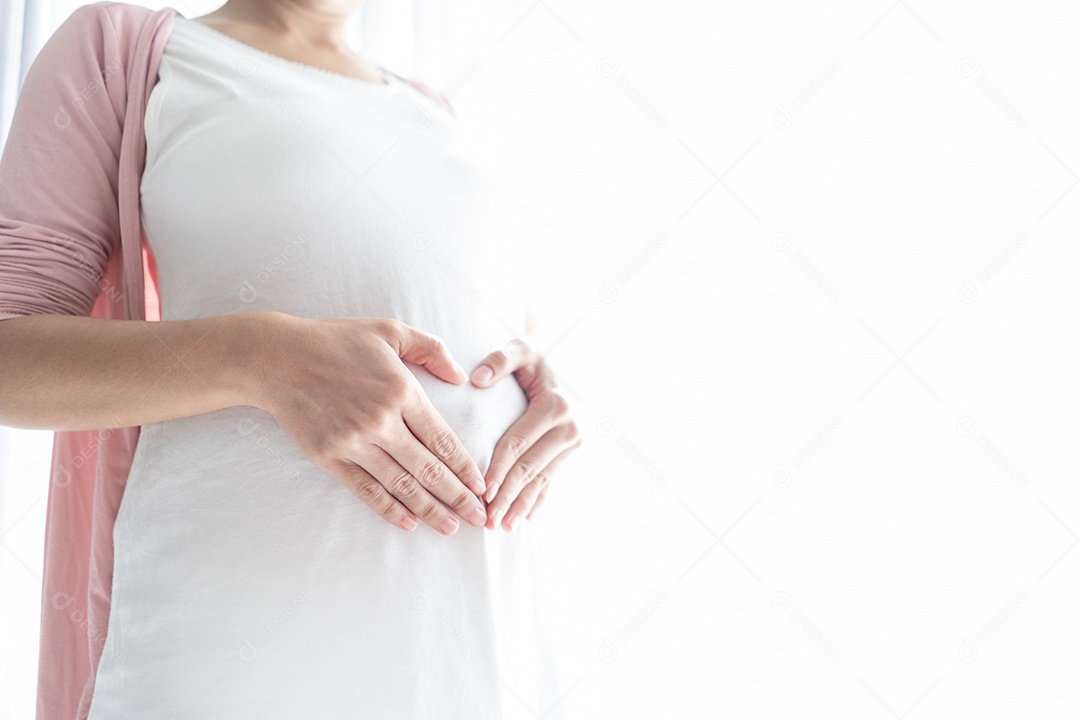 Mãe esperando bebê para uma mulher saudável e grávida tocando a barriga.